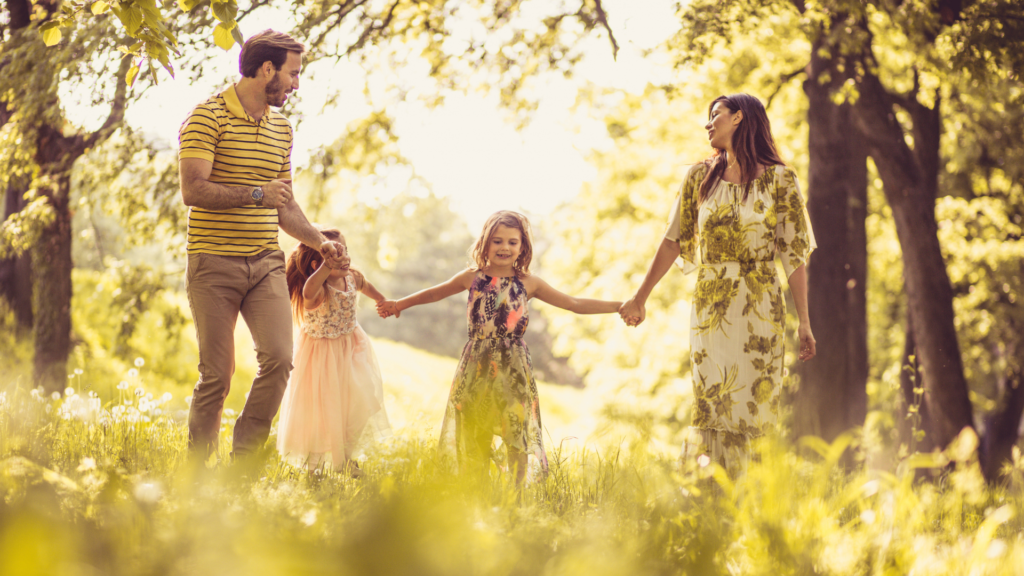 Glad familie i naturen - symbolet på den trivsel og tryghed, vi arbejder for at skabe for familier hos Family Lighttower.